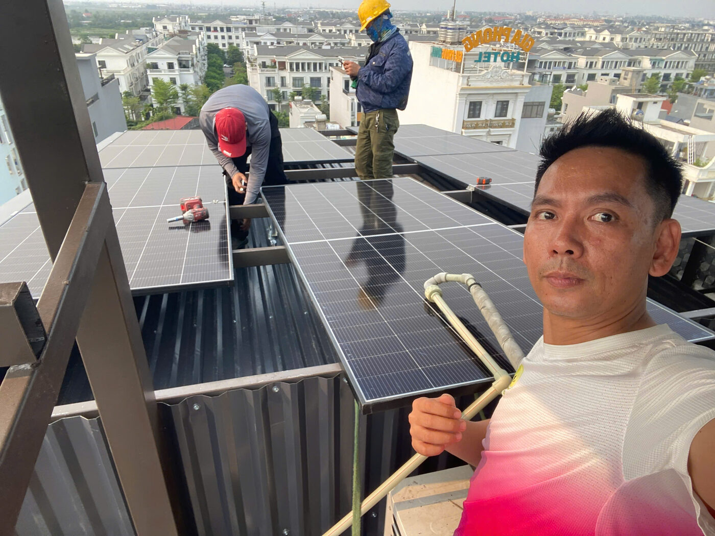 Công nhân đưa tấm pin 620W lên vị trí lắp trên mái